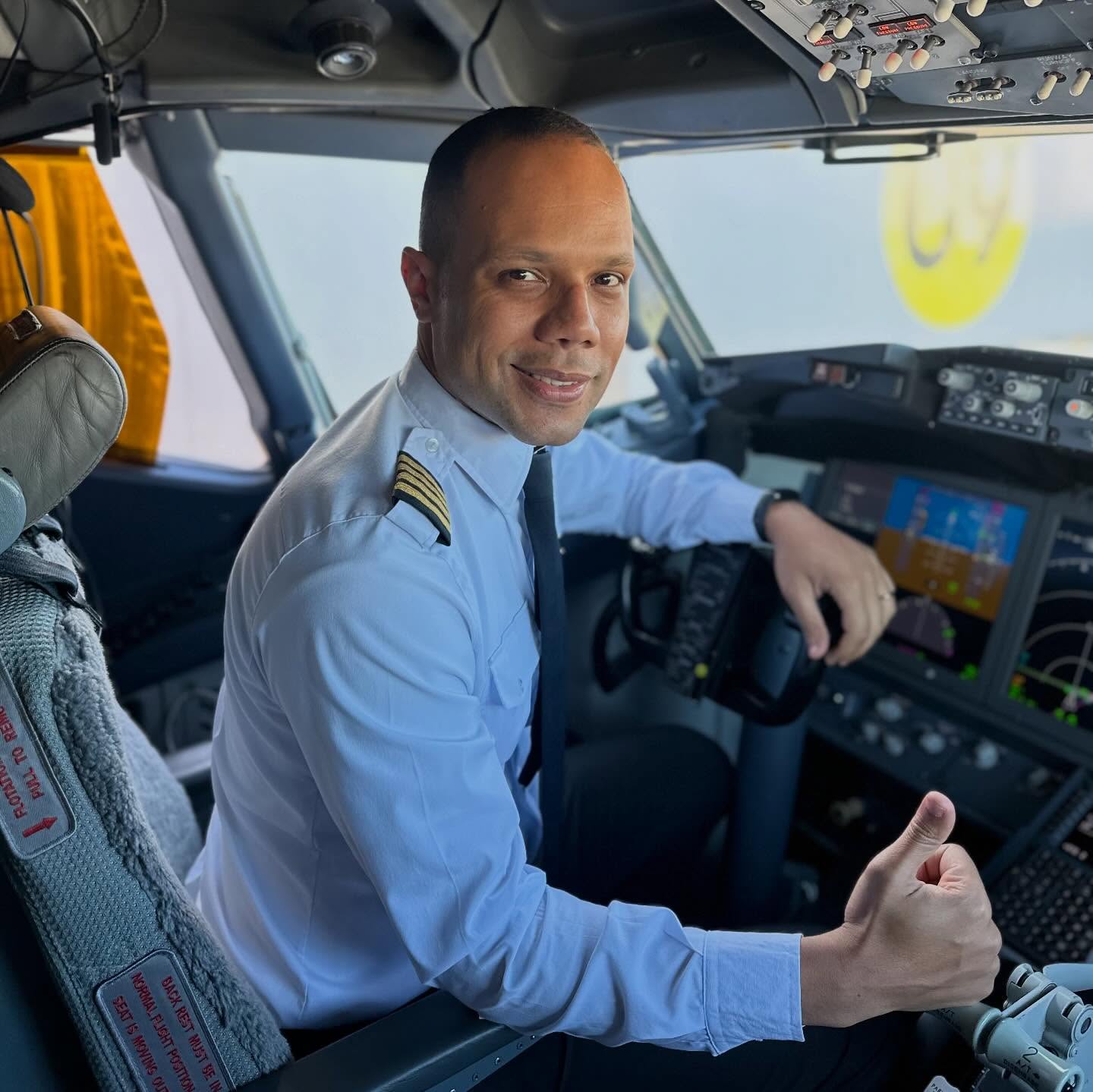 Comandante Luis Pita sorrindo dentro da cabine de comando de um Boeing 737